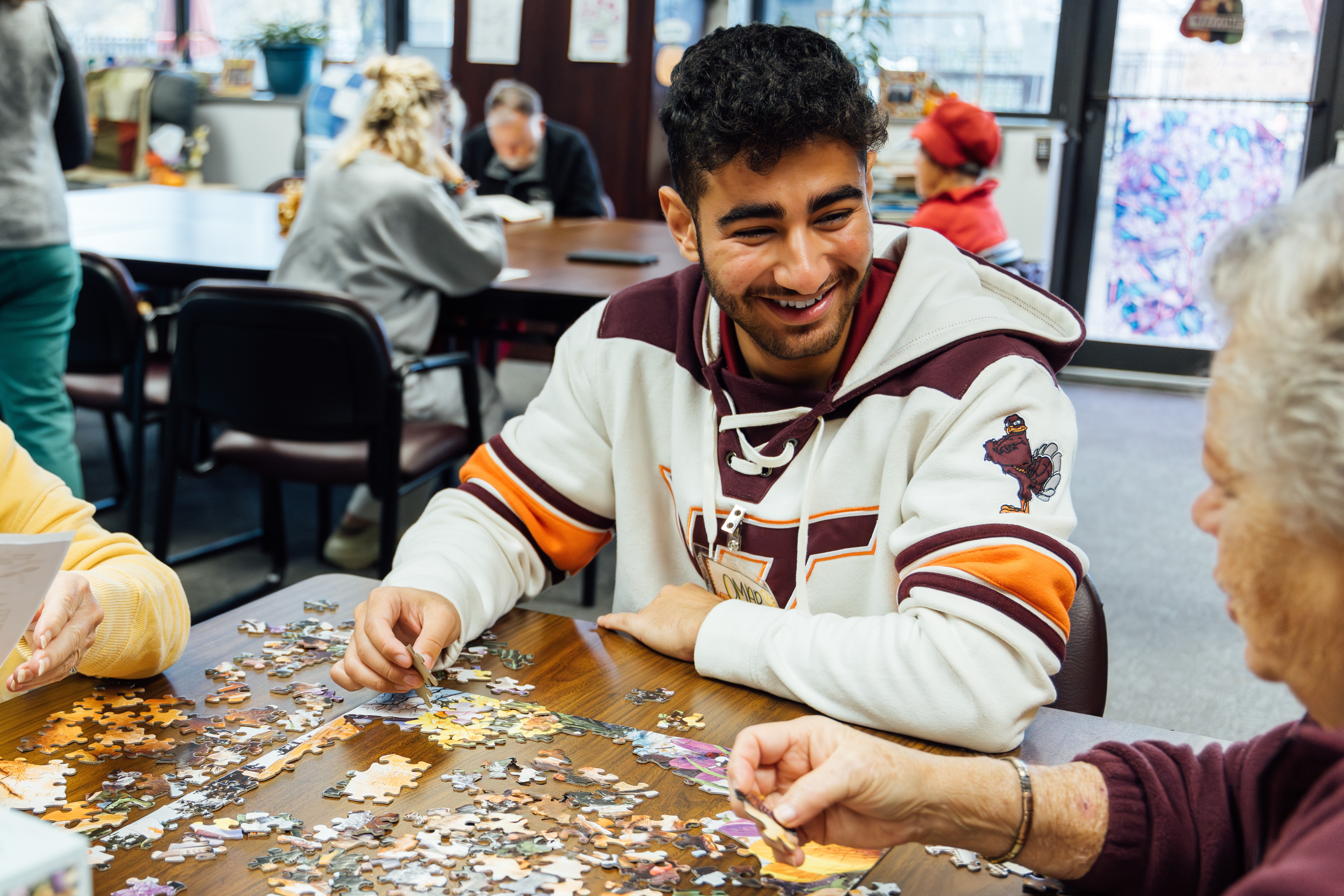 young man smiling while doing a puzzle 